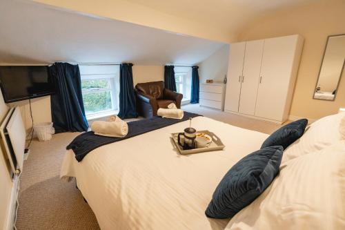 a bedroom with a large bed and a chair at Church Cottage in Maryport