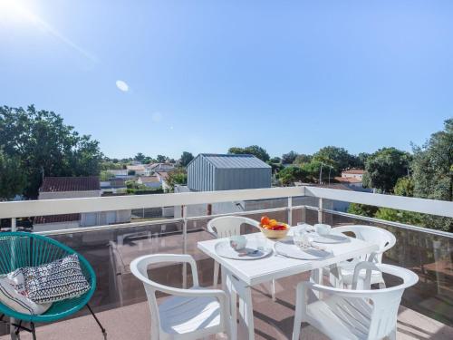 une table blanche et des chaises sur un balcon dans l'établissement Apartment Les Fées de Mirbois by Interhome, à Vaux-sur-Mer