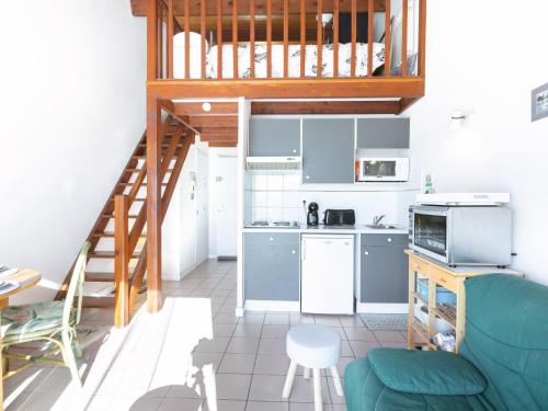 un salon avec un canapé bleu et une cuisine dans l'établissement Apartment Les Fées de Mirbois by Interhome, à Vaux-sur-Mer