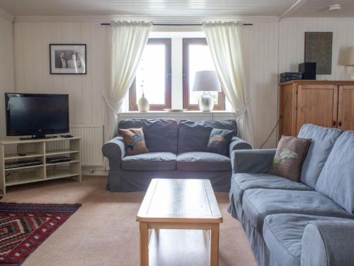 a living room with a couch and a tv at Holiday Home Ploughman by Interhome in Eyre