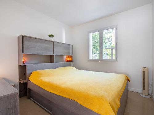 une chambre avec un grand lit avec une couverture jaune dans l'établissement Holiday Home Villa Les Treilles by Interhome, à Le Racou
