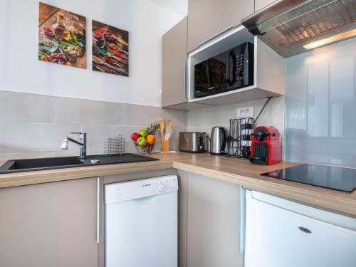 une cuisine avec des armoires blanches et un évier dans l'établissement Apartment Océan-2 by Interhome, à Carnac