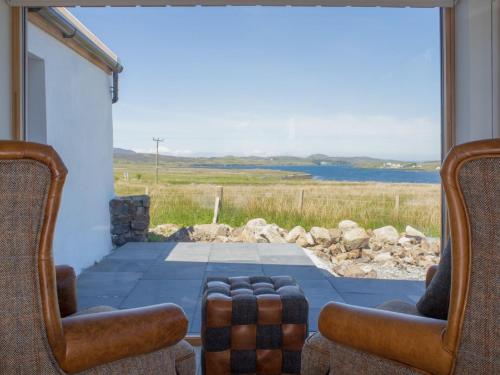 - une chambre avec deux chaises et une vue sur l'eau dans l'établissement Holiday Home Finnan's Byre by Interhome, à Eyre