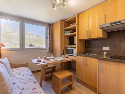 a kitchen with wooden cabinets and a table in a room at Studio Palafour - Le Lac-5 by Interhome in Tignes