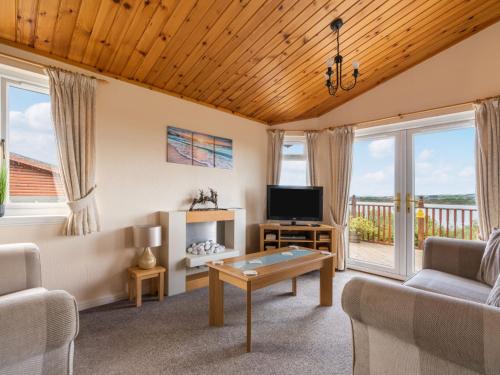 uma sala de estar com um sofá e uma televisão em Chalet Loch Side Lodge 5 by Interhome em Kinross