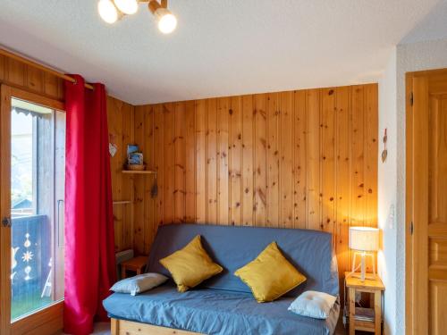 - un canapé bleu dans une chambre dotée d'un mur en bois dans l'établissement Apartment Aiguilles du Midi by Interhome, à Saint-Gervais-les-Bains