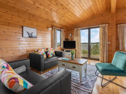 un salon avec un canapé, des fauteuils et une télévision dans l'établissement Chalet Loch Side Lodge 8 by Interhome, à Kinross