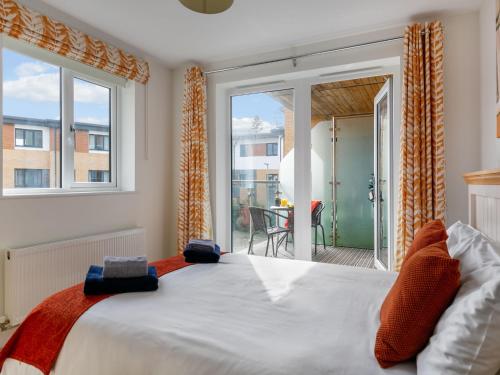 een slaapkamer met een groot bed en een balkon bij Apartment Stones Throw by Interhome in St Austell