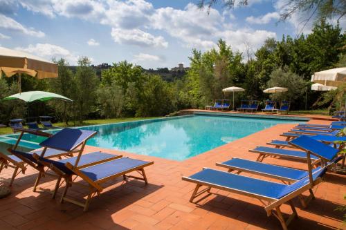 una piscina con tumbonas azules y un montón de plantas en Agriturismo Borgo dei Ricci, en Impruneta