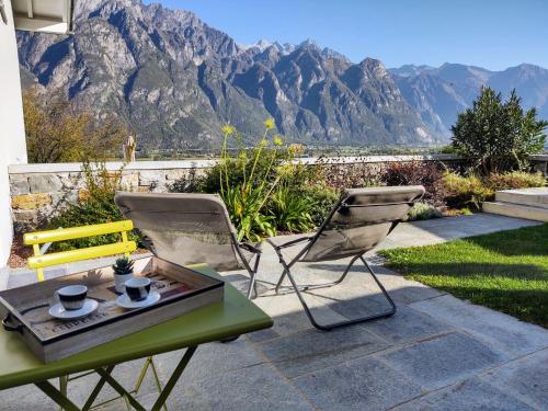a table and chairs on a patio with mountains in the background at Apartment Ronscione Bellavista by Interhome in San Cassiano