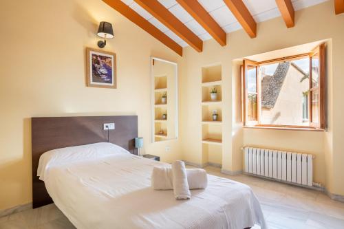 a bedroom with a large white bed and a window at Villa sa Palmera in Ses Salines