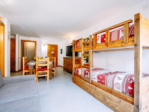a bedroom with two bunk beds and a dining room at Apartment Torrita di Canazei by Interhome in Alba di Canazei
