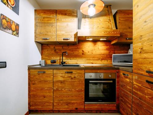 a kitchen with wooden cabinets and a sink at Apartment Torrita di Canazei by Interhome in Alba di Canazei