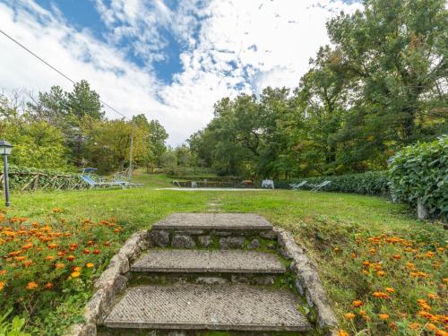 a stone bench in a field with flowers at Holiday Home Il Feudo by Interhome in Poggioni