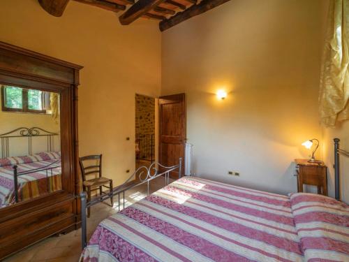 a bedroom with a bed and a chair in it at Holiday Home Il Feudo by Interhome in Poggioni