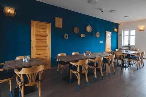 a dining room with blue walls and wooden tables and chairs at Kormorán Vendégház in Tiszafüred