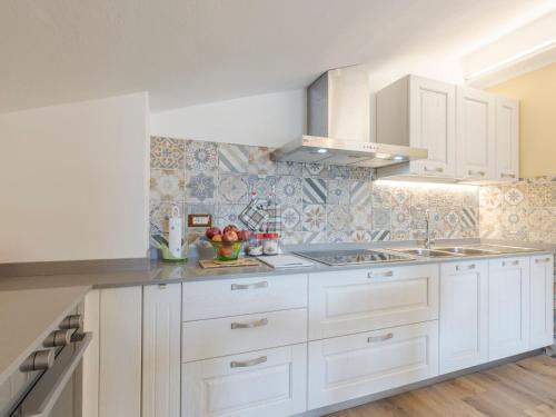 una cocina con armarios blancos y fregadero en Apartment Gabriella by Interhome, en Pontedassio