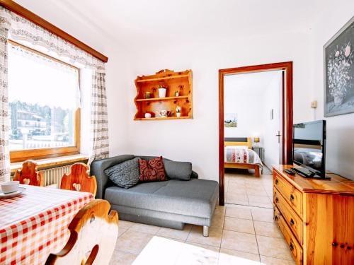 ein Wohnzimmer mit einem Bett, einem Sofa und einem TV in der Unterkunft Apartment Cesa Minach-3 by Interhome in Alba di Canazei
