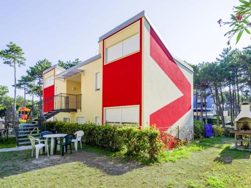 a house with a red and white wall at Apartment Primula by Interhome in Bibione