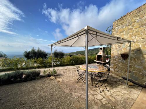 stół i krzesła pod parasolem na tarasie w obiekcie Holiday Home Casa Chiara by Interhome w mieście Castellina in Chianti
