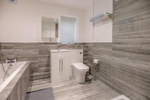 een badkamer met een toilet, een wastafel en een bad bij 4 Eureka Waldringfield Air Manage Suffolk in Woodbridge