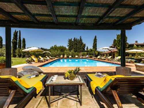 una piscina con sedie gialle e tavolo e una piscina di Villa La Torre by Interhome a Figline Valdarno