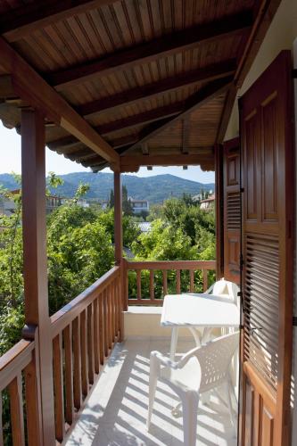 a wooden deck with a table and chairs on it at Pansion Matoula in Skiathos Town
