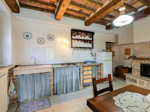 a kitchen with a table and a stove top oven at Holiday Home Turi by Interhome in Roccatederighi