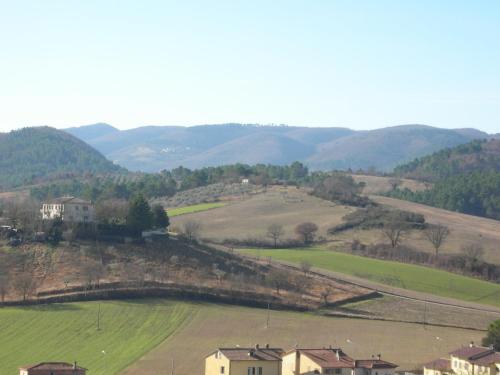 a view of a field and hills with houses at Agriturismo San Vito in Crocemaroggia