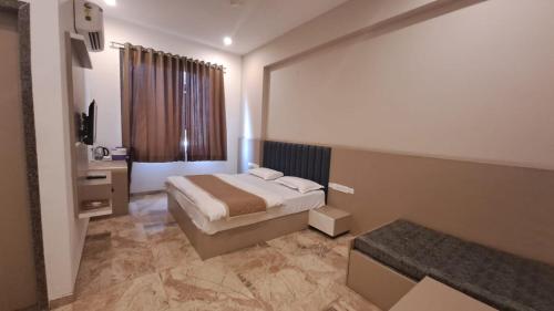 Rājsamandにあるhotel keshav innのベッドルーム1室(ベッド1台、デスク、窓付)