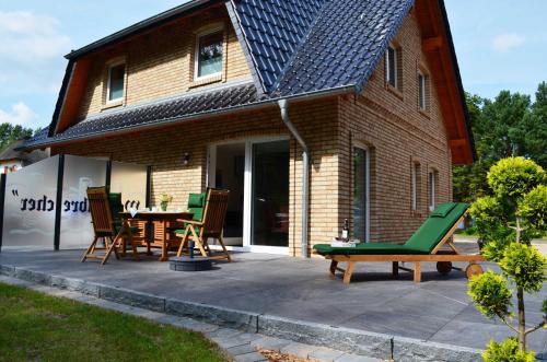 a patio with chairs and a table in front of a house at Ferienhaus Wellenbrecher in Ostseebad Karlshagen