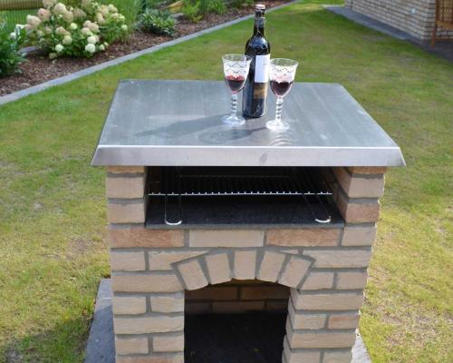 a stone table with two glasses of wine and a bottle at Ferienhaus Wellenbrecher in Ostseebad Karlshagen