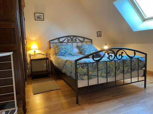 a bedroom with a bed with blue pillows and a window at Chez MARLENE in Quettehou