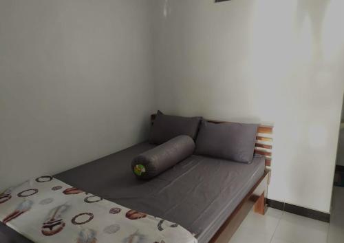 ein Bett in einem Zimmer neben einer Wand in der Unterkunft Homestay Mami Borobudur in Borobudur