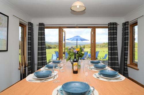 a dining room with a long table with glasses and flowers at Kennacraig Lodge in Whitehouse