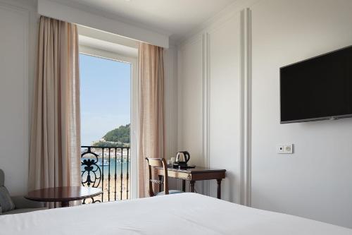 a hotel room with a bed and a window with a view at Hotel de Londres y de Inglaterra in San Sebastián