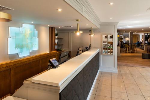 a bar in a salon with a large screen at Holiday Inn Birmingham M6, Jct7 by IHG in Birmingham