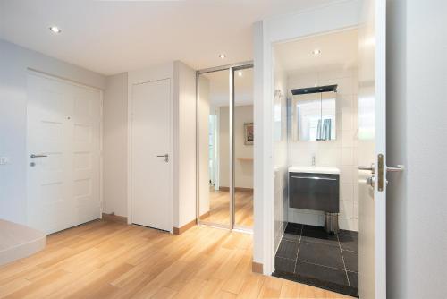 een badkamer met een douche, een wastafel en een toilet bij Hello Zeeland - Appartement Loverendale 10 in Domburg