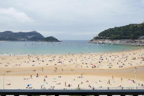 un grupo de personas en una playa en Hotel de Londres y de Inglaterra en San Sebastián