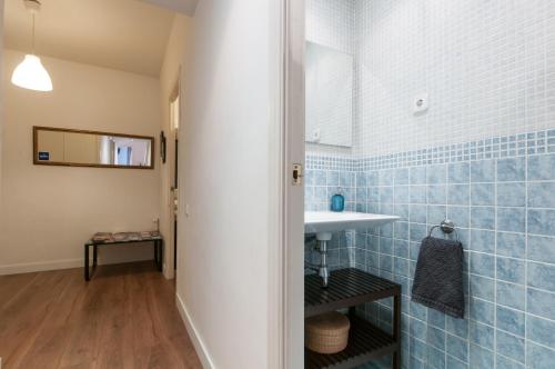 uma casa de banho com lavatório e azulejos azuis em Aribau em Barcelona