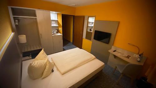 Habitación de hotel con cama, escritorio y habitación en Hotel Windspiel en Grömitz