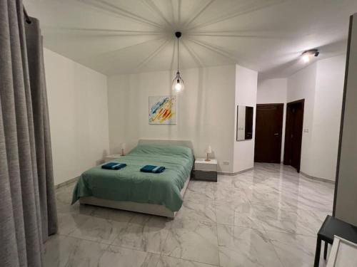 a bedroom with a green bed in a white room at Mediterranean Escape - 3 Bedroom Apartment Gozo in Żebbuġ