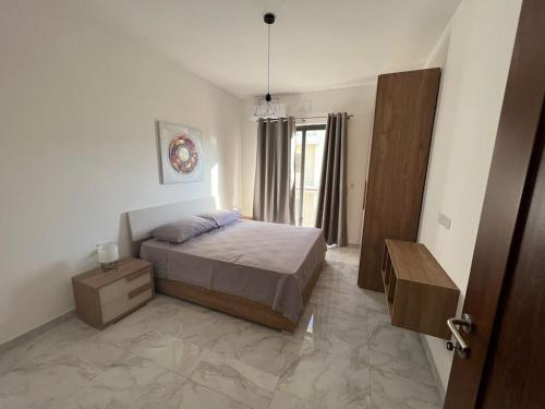 Żebbuġ的住宿－Gozo - 3 Bedroom - Brand New，一间卧室配有一张床、一个梳妆台和一扇窗户。