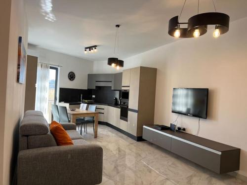 a living room with a couch and a tv at Gozo - 3 Bedroom - Brand New in Żebbuġ