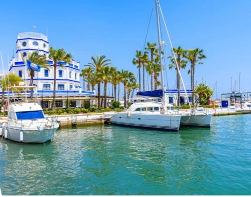 three boats docked in a marina in front of a building at Prachtig appartement met zeezicht in Estepona Costa del Sol in Estepona