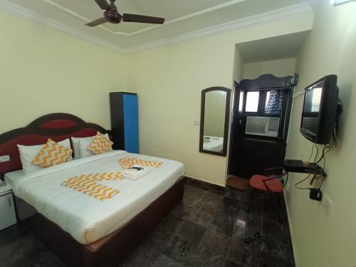 Un pat sau paturi într-o cameră la The Dolphin Park Hotel, Virugambakkam
