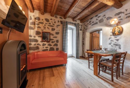 a living room with a red couch and a table at Historic Residence Madonna in San Martino di Castrozza