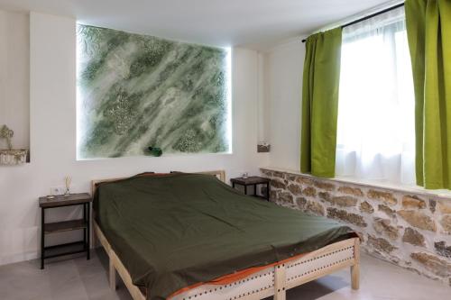 um quarto com uma cama e uma janela com cortinas verdes em Cozy House Bohot Relax, Къща за гости Бохот Релакс em Khotnitsa