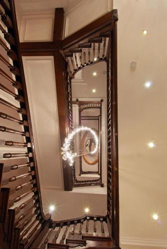a mirror on the side of a stairway with a mirror at Park Grand Mayfair in London