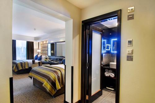 a hotel room with a bed and a bathroom at Park Grand Mayfair in London